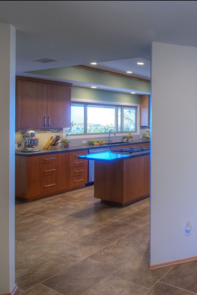 La Mesa kitchen remodel with wood cabinetry, cooktop island, tile flooring, wide sink window and recessed lighting