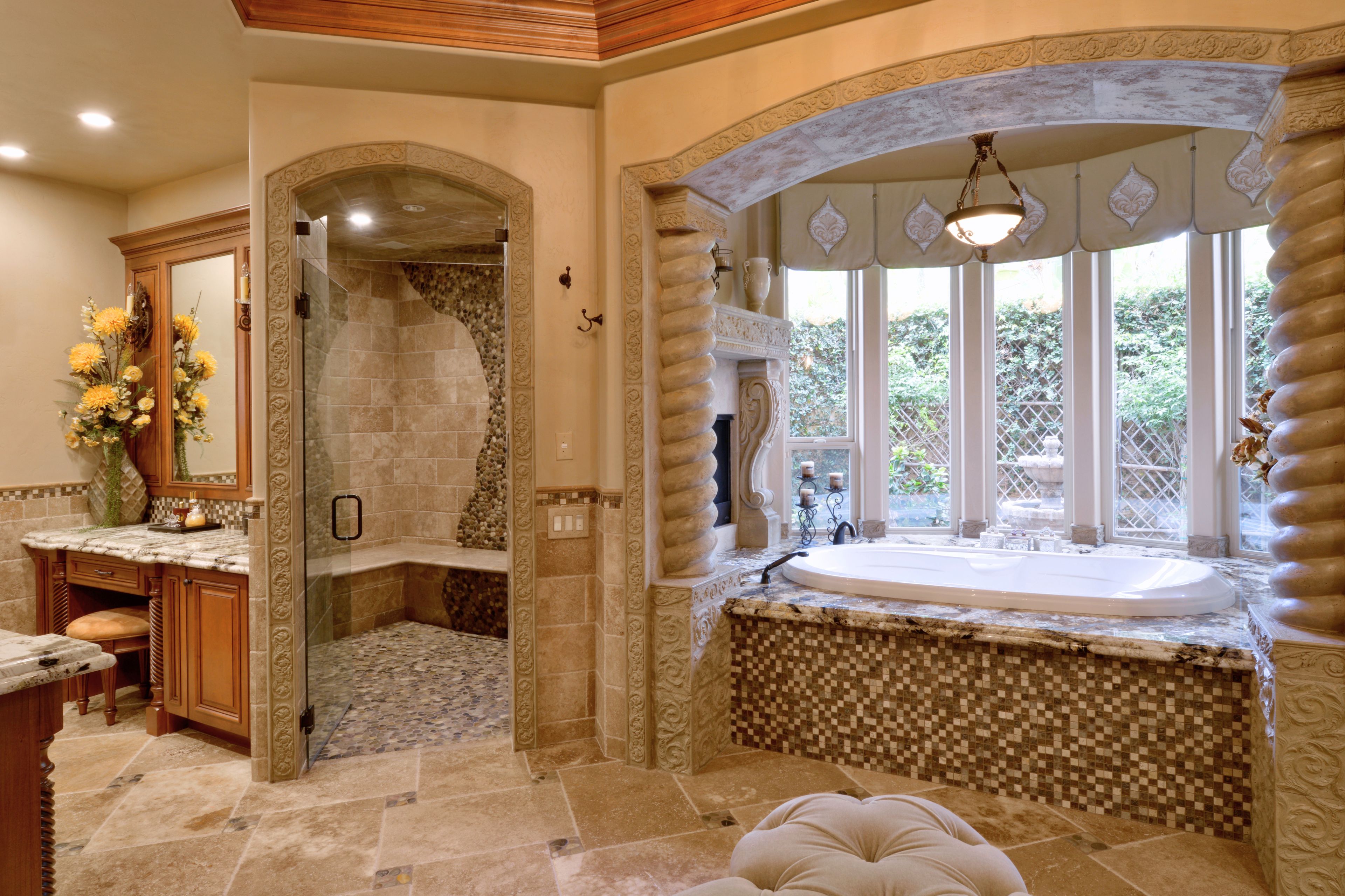 Primary bathroom remodel with tiled shower, built-in bench, jetted tub, stone surround and custom wood vanity.