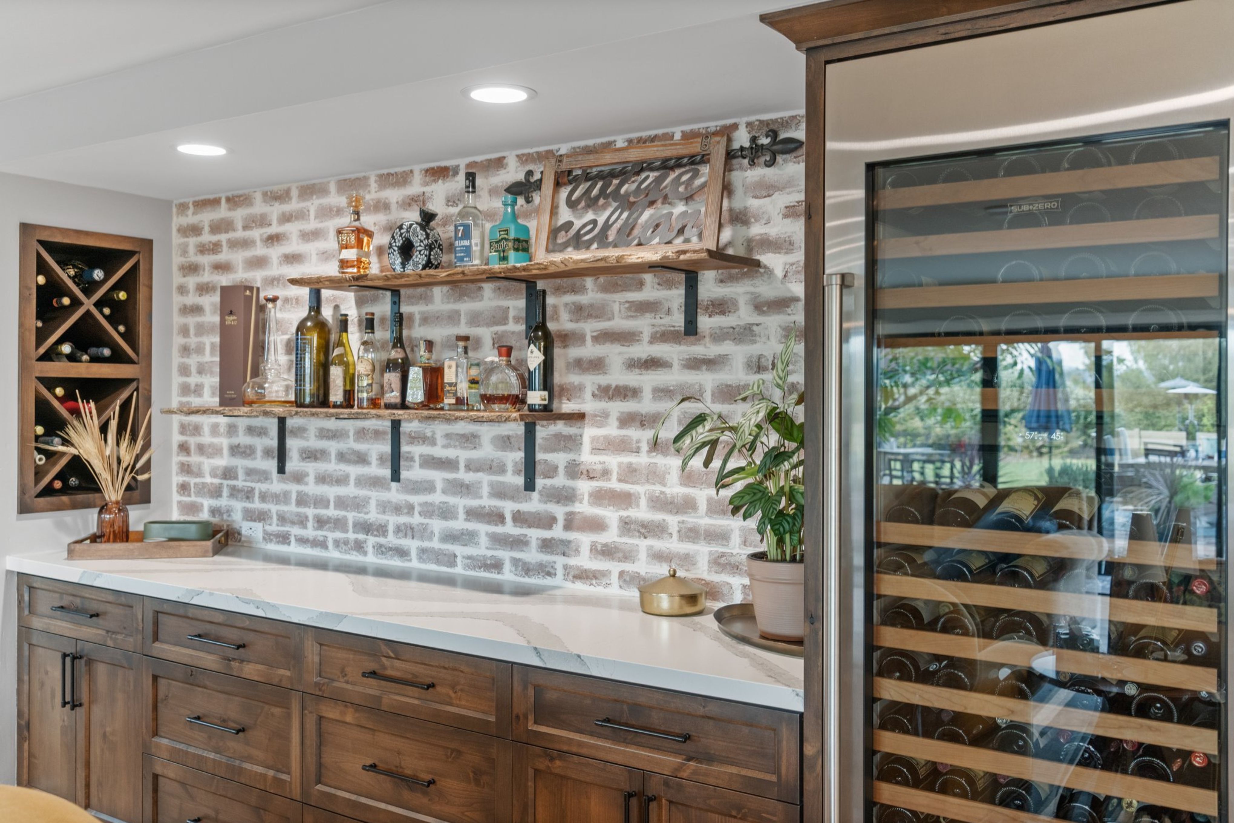 Built-in home bar with wood cabinetry, quartz counter, brick accent wall, open shelves and glass-front wine refrigerator.