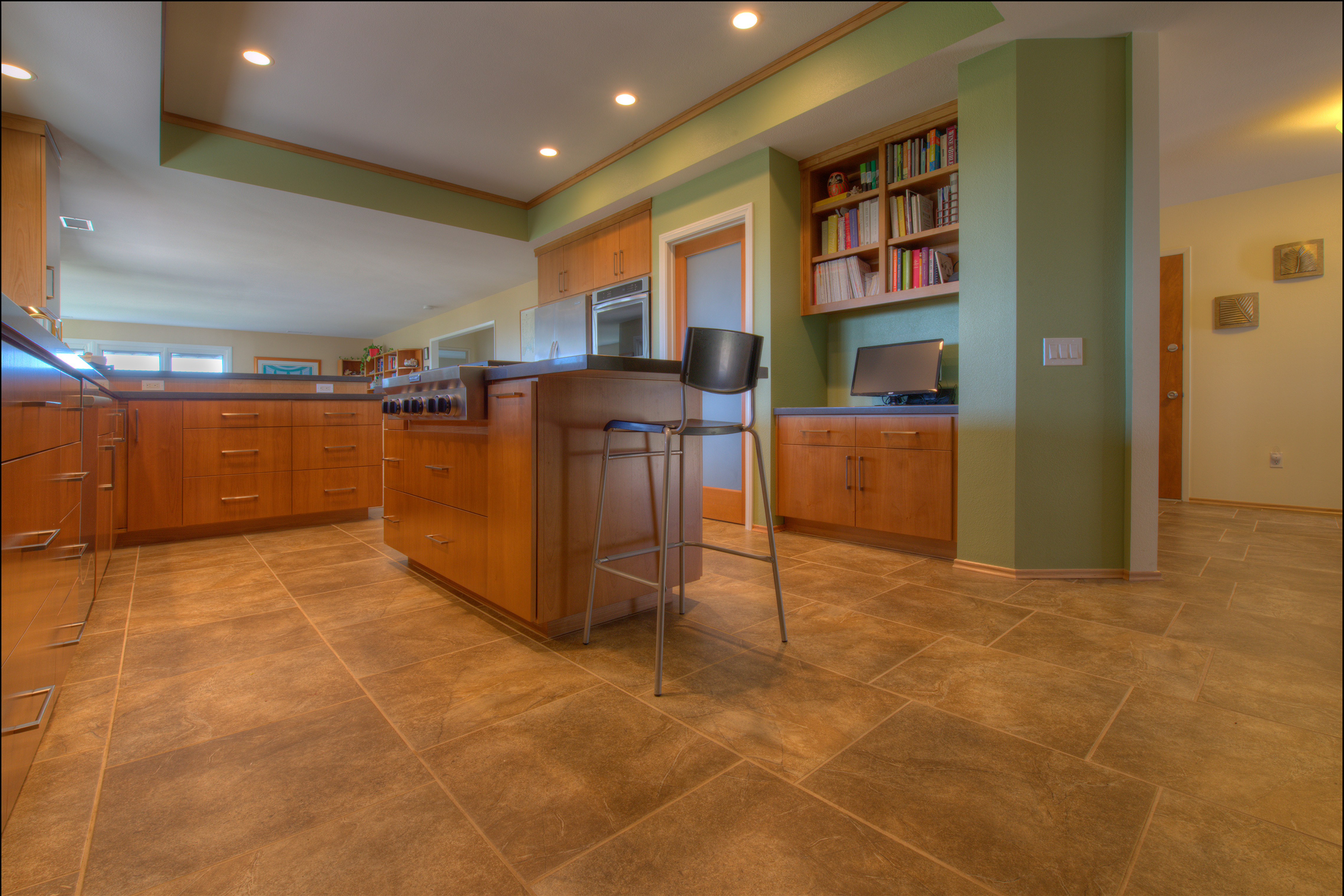 Open La Mesa kitchen with wood cabinetry, peninsula seating, tile floors, recessed lighting and built-in shelving.