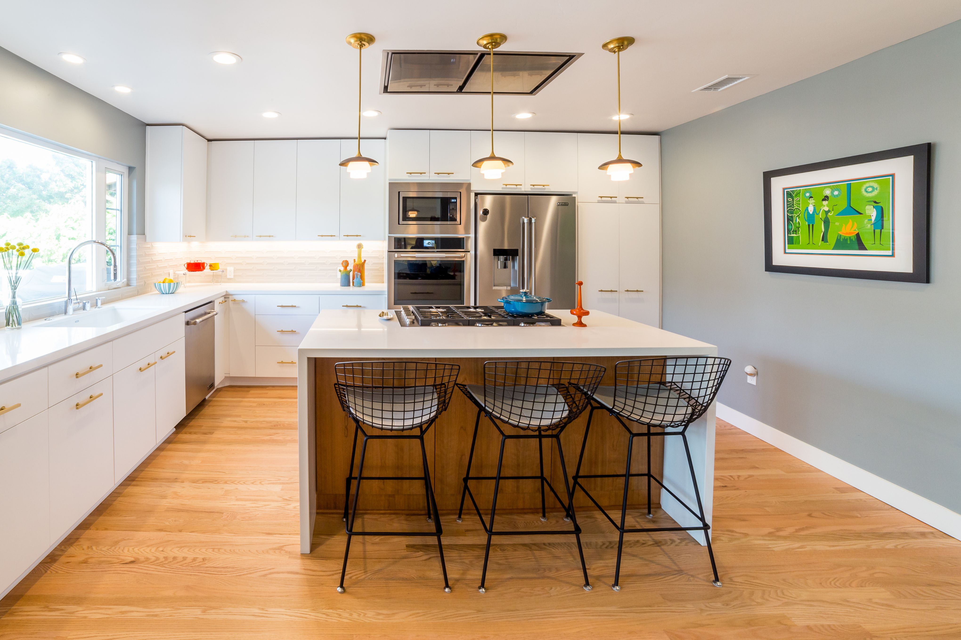 North Kensington kitchen with white cabinetry, large island, brass pendants, stainless appliances and wood flooring
