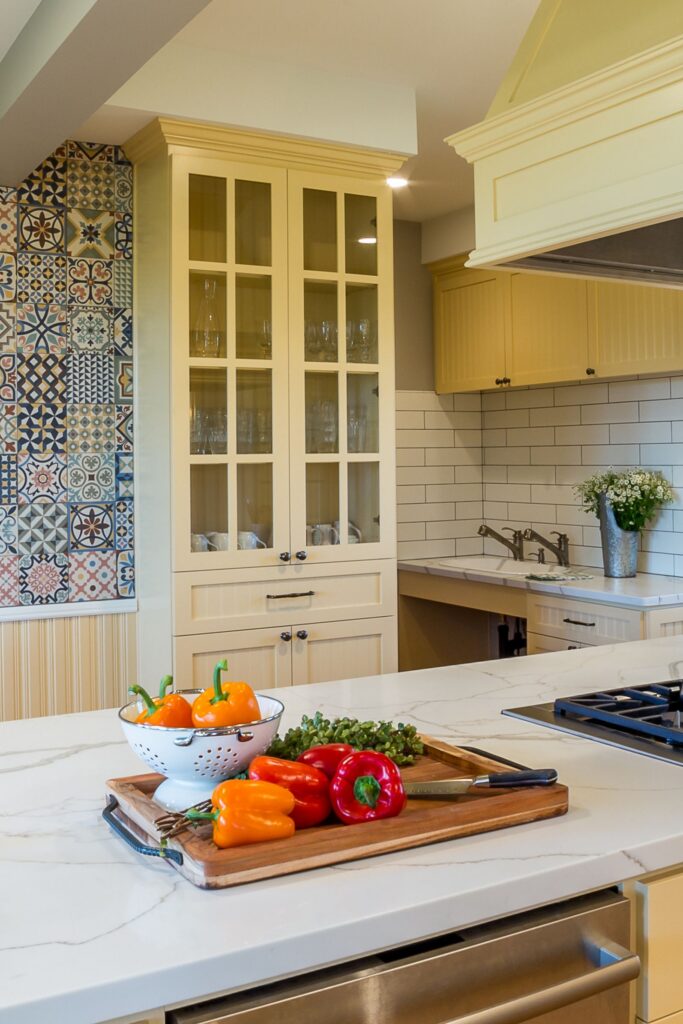 National City kitchen with cream glass-front cabinetry, patterned tile accent wall and white countertops