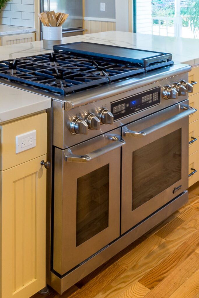 Stainless double-oven range with griddle, cream cabinetry and warm wood flooring
