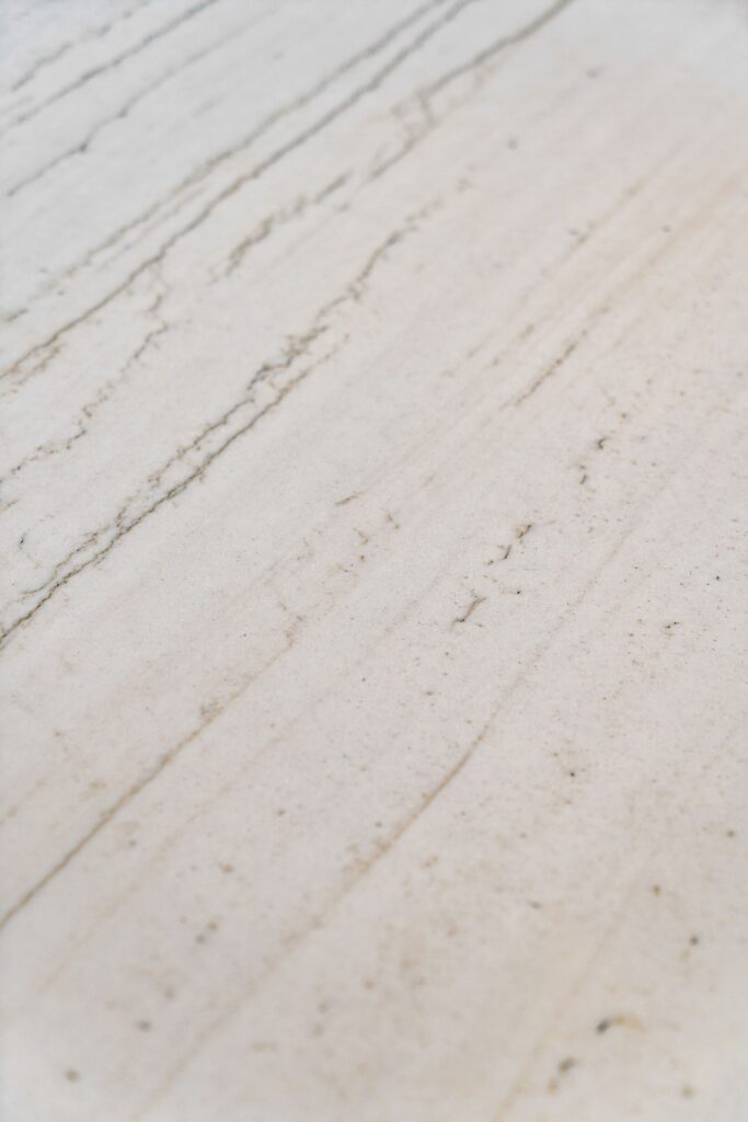 Close-up of white solid-surface kitchen countertop with subtle gray and beige veining.