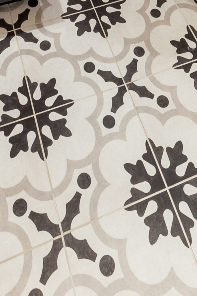 Close-up of black, white and gray patterned bathroom floor tile with repeating floral motif