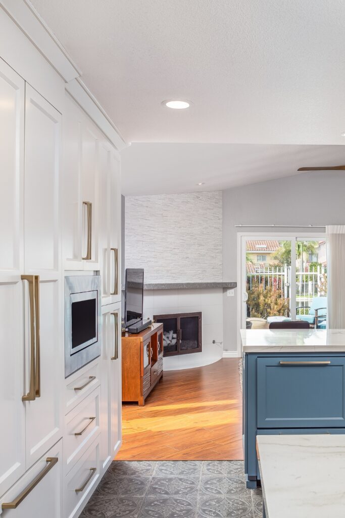View from kitchen pantry wall toward family room fireplace and sliding glass door