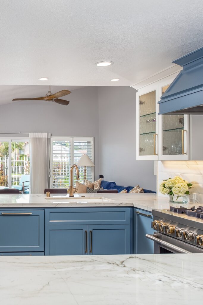 Open kitchen and family room layout with blue cabinetry, chevron backsplash and sliding glass door