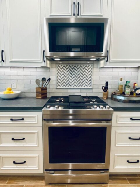 Carlsbad kitchen remodel with white cabinetry, apron-front sink, gray counters, wood shelving and subway tile backsplash.
