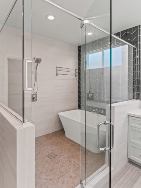 Carmel Valley bathroom conversion with glass shower, freestanding tub, chevron tile and frosted window.