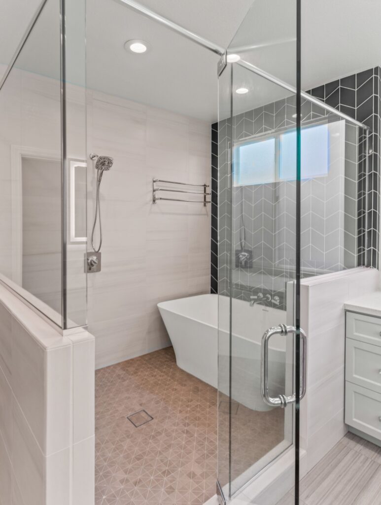 Carmel Valley bathroom conversion with glass shower, freestanding tub, chevron tile and frosted window.