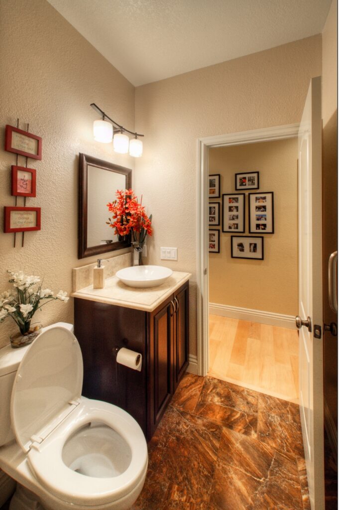 Powder room with vessel sink, dark wood vanity and marble-pattern floor tile