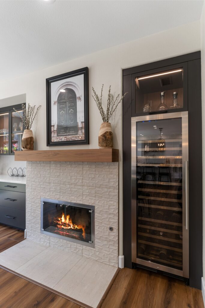 Refaced dining room fireplace with textured tile, wood mantel and built-in glass-front wine refrigerator