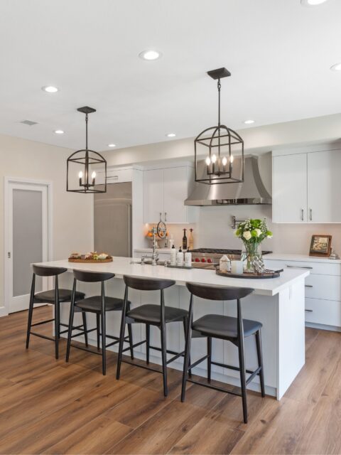 Chula Vista kitchen remodel with white cabinetry, large island seating, lantern pendants and stainless range hood