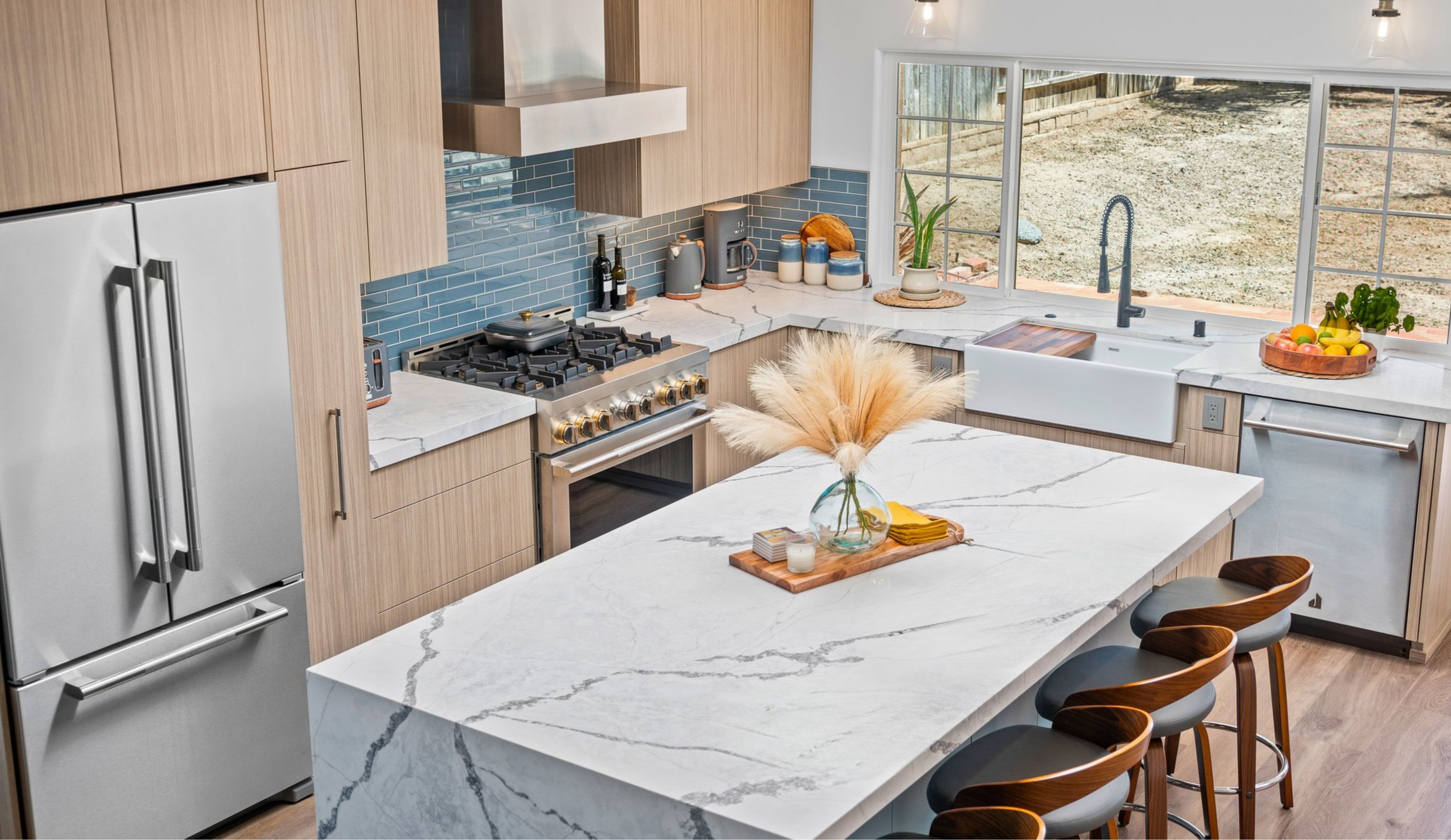 Del Mar kitchen remodel with waterfall island, light wood cabinetry, blue tile backsplash, farmhouse sink and stainless appliances.