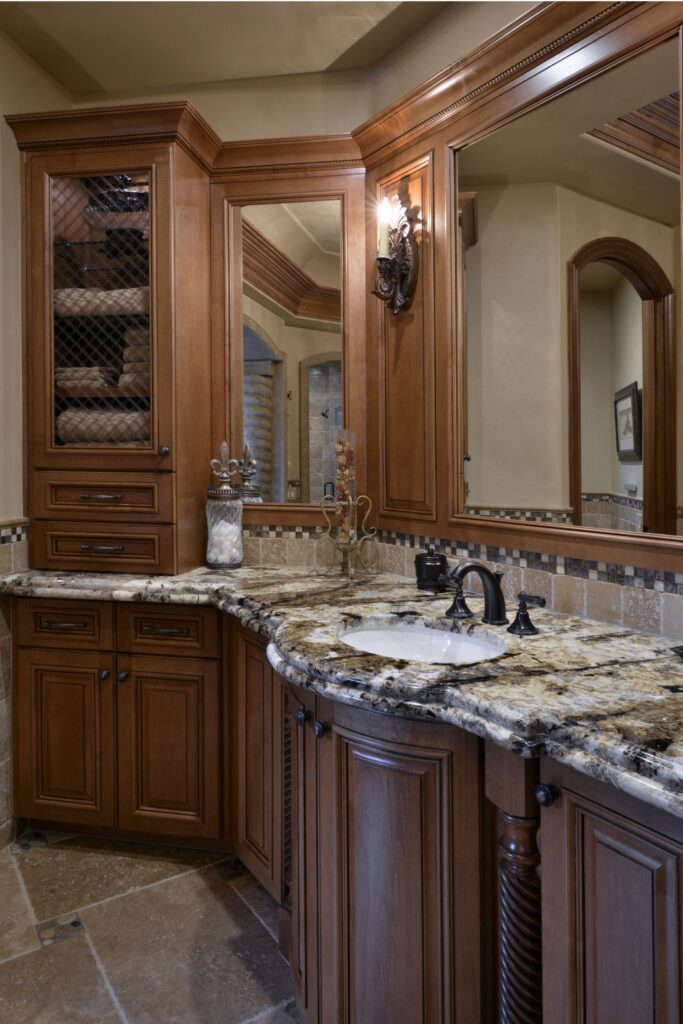 El Cajon bathroom vanity with custom wood cabinetry, granite countertop, framed mirrors and decorative sconces.