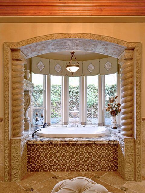 El Cajon bathroom remodel with soaking tub, granite surround, mosaic tile, carved stone arch and spiral columns.