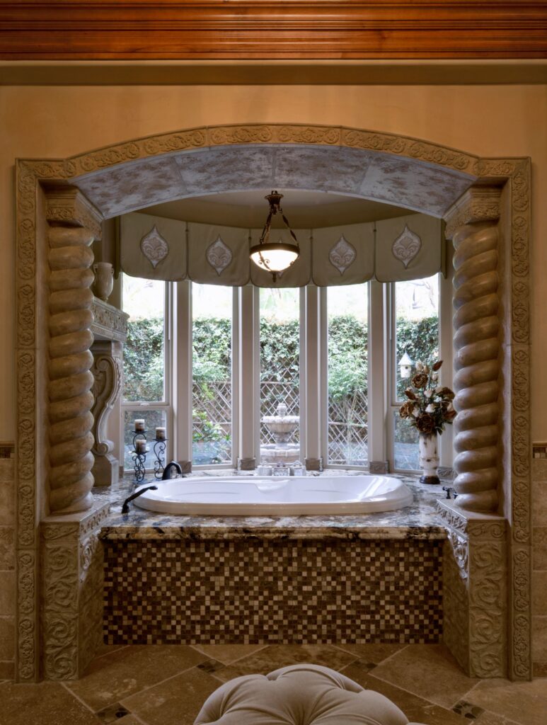 El Cajon bathroom remodel with soaking tub, granite surround, mosaic tile, carved stone arch and spiral columns.