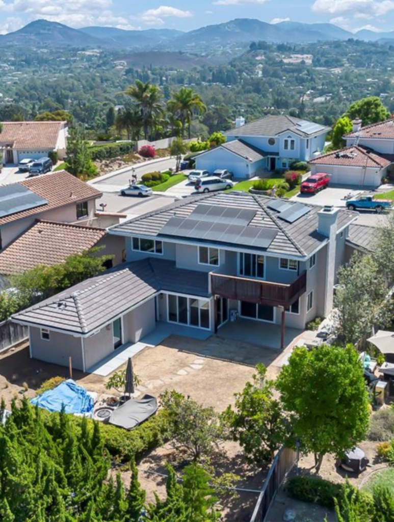 Encinitas whole-home remodel and addition with two-story rear elevation, covered patio, upper deck and large sliding glass doors.