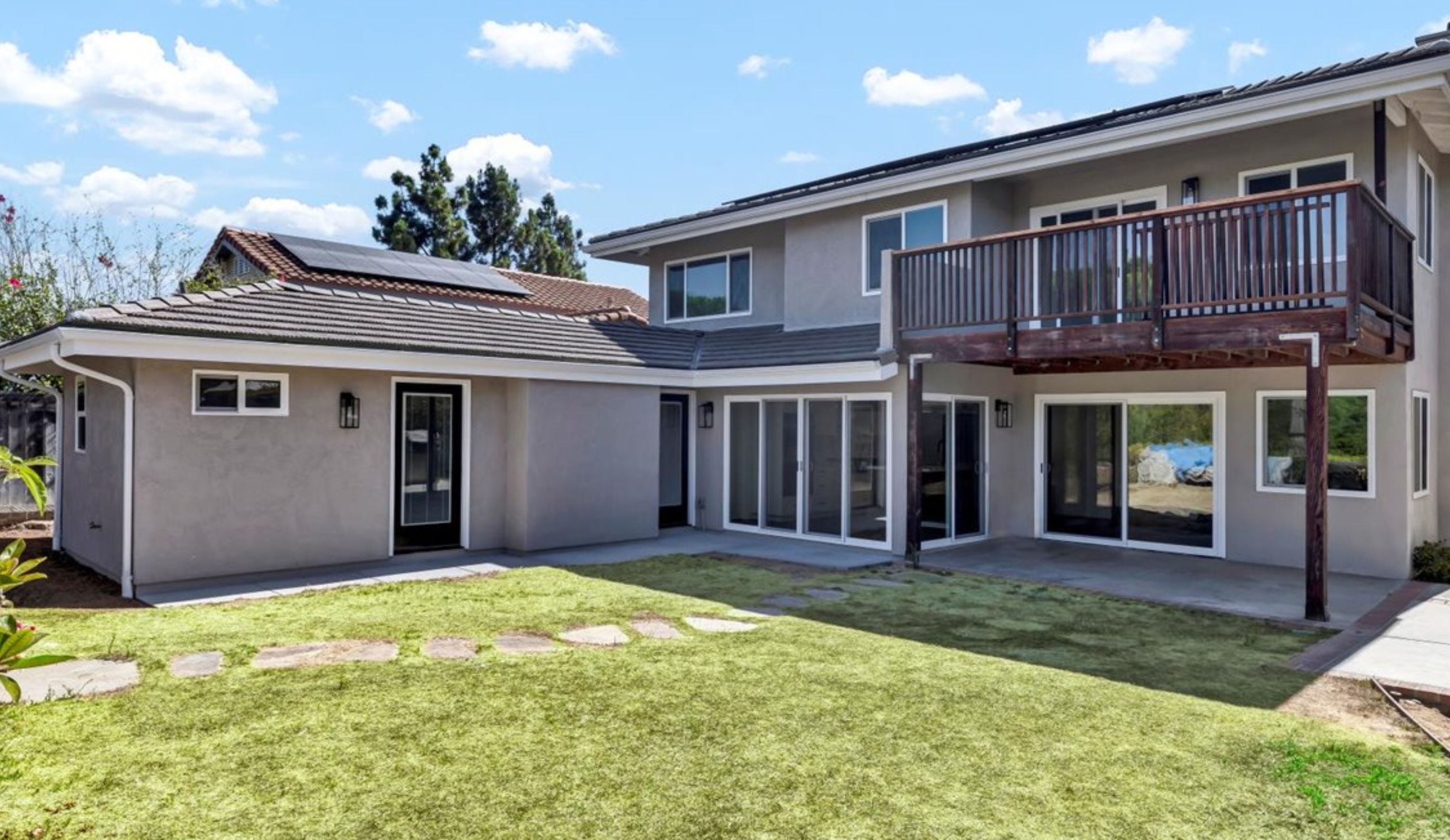 Aerial view of an Encinitas home addition and remodel with updated rooflines, solar panels, rear deck and expanded backyard footprint.