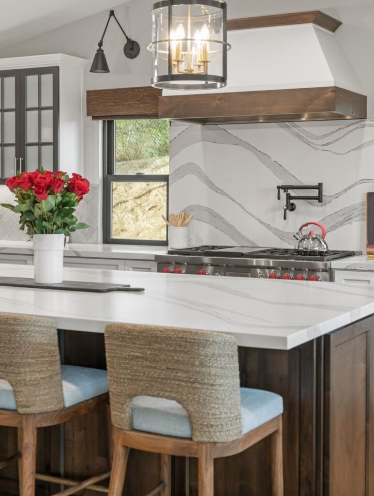 Encinitas kitchen remodel with dark wood island, white quartz counters, custom range hood, statement backsplash and pendant lighting.