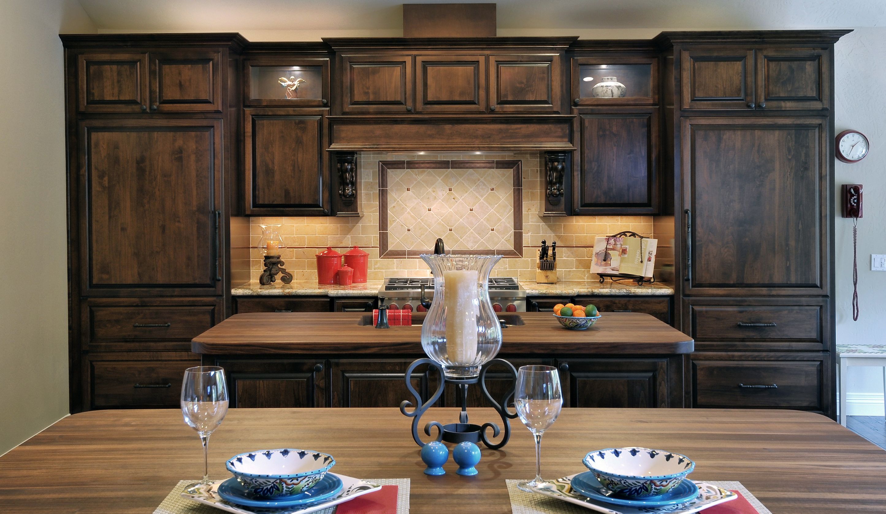 Escondido kitchen remodel with dual walnut-topped islands, dark wood cabinetry, stone backsplash and range