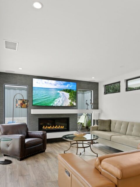 San Diego interior remodel with family room fireplace, wall-mounted TV, clerestory windows and wood-look flooring.