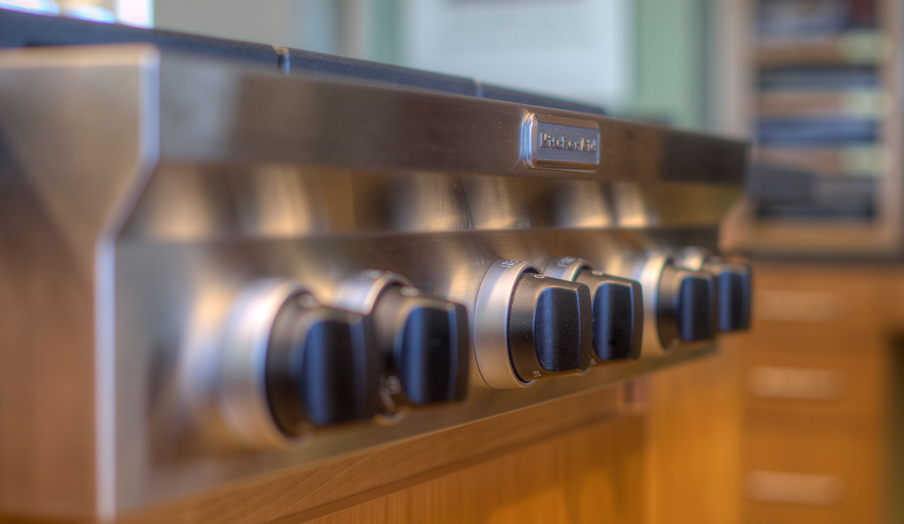 La Mesa kitchen remodel detail with stainless cooktop controls integrated into warm wood cabinetry.