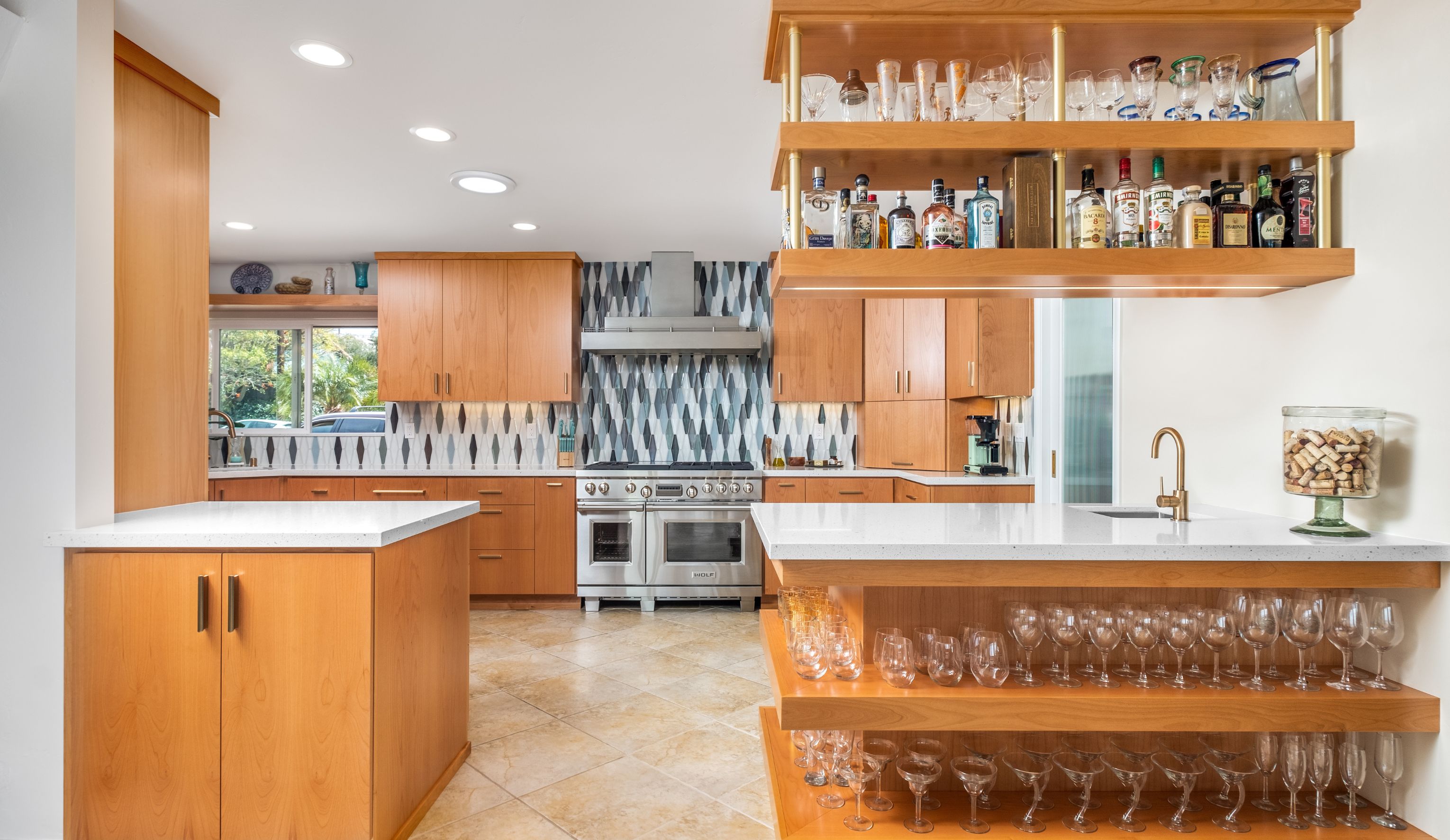 La Mesa kitchen remodel with warm wood cabinetry, geometric backsplash, large range and suspended wet bar shelving