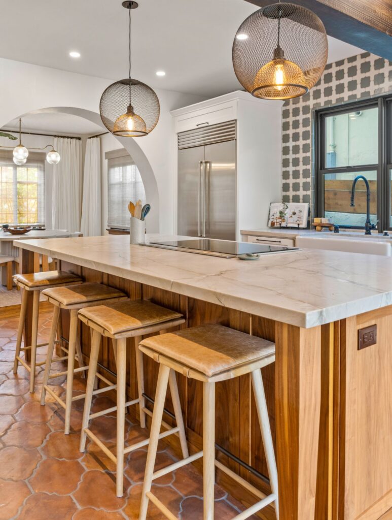 Mission Hills kitchen remodel with wood island, stone countertop, pendant lights, arched opening and stainless refrigerator