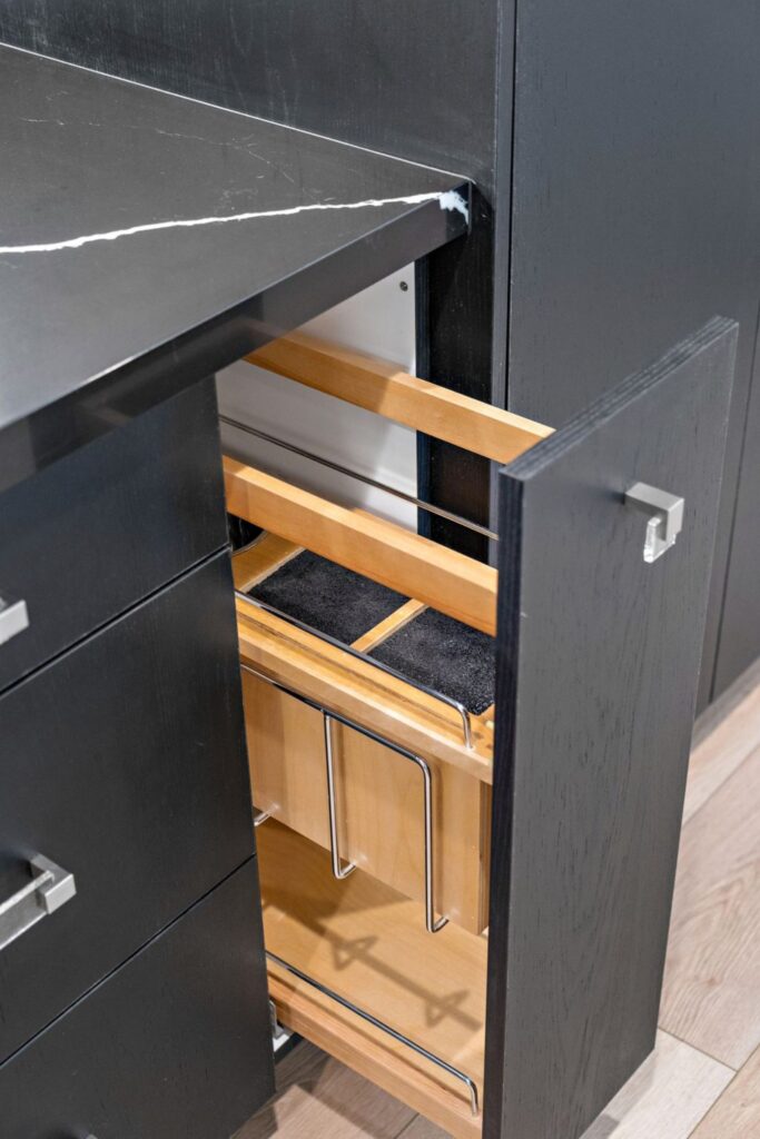Pull-out kitchen cabinet organizer with wood interior, metal rails and black cabinetry