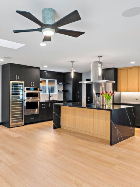 San Diego whole-home remodel with open kitchen, black cabinetry, wood island, waterfall counter and stainless appliances