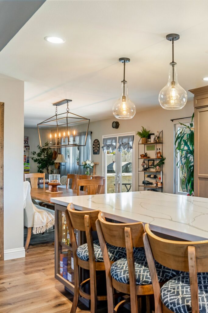 Open kitchen island with waterfall quartz counter, bar seating and dining room beyond