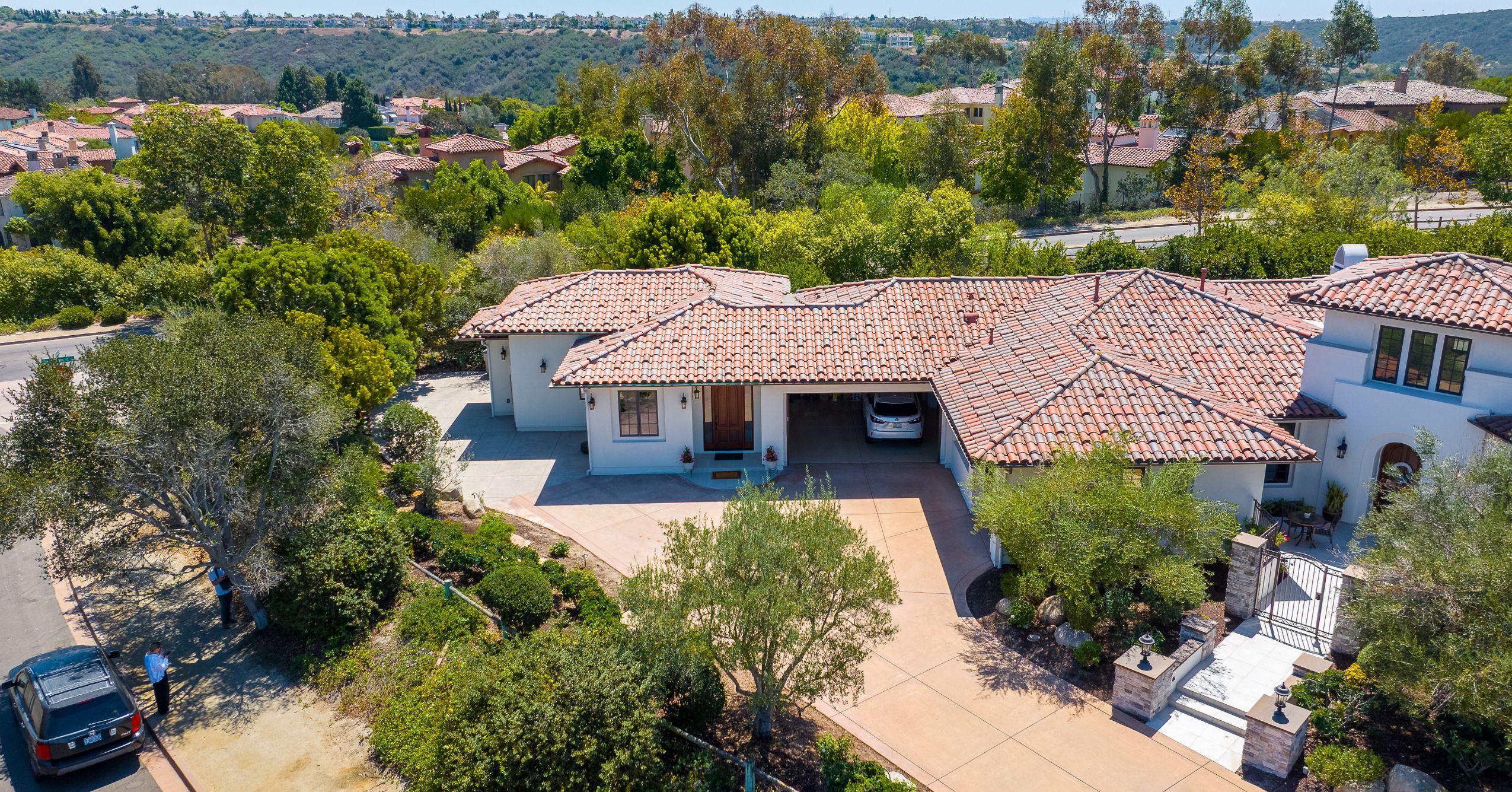 Aerial view of the attached ADU and main home with Mediterranean-style tile roofing and surrounding landscaping.
