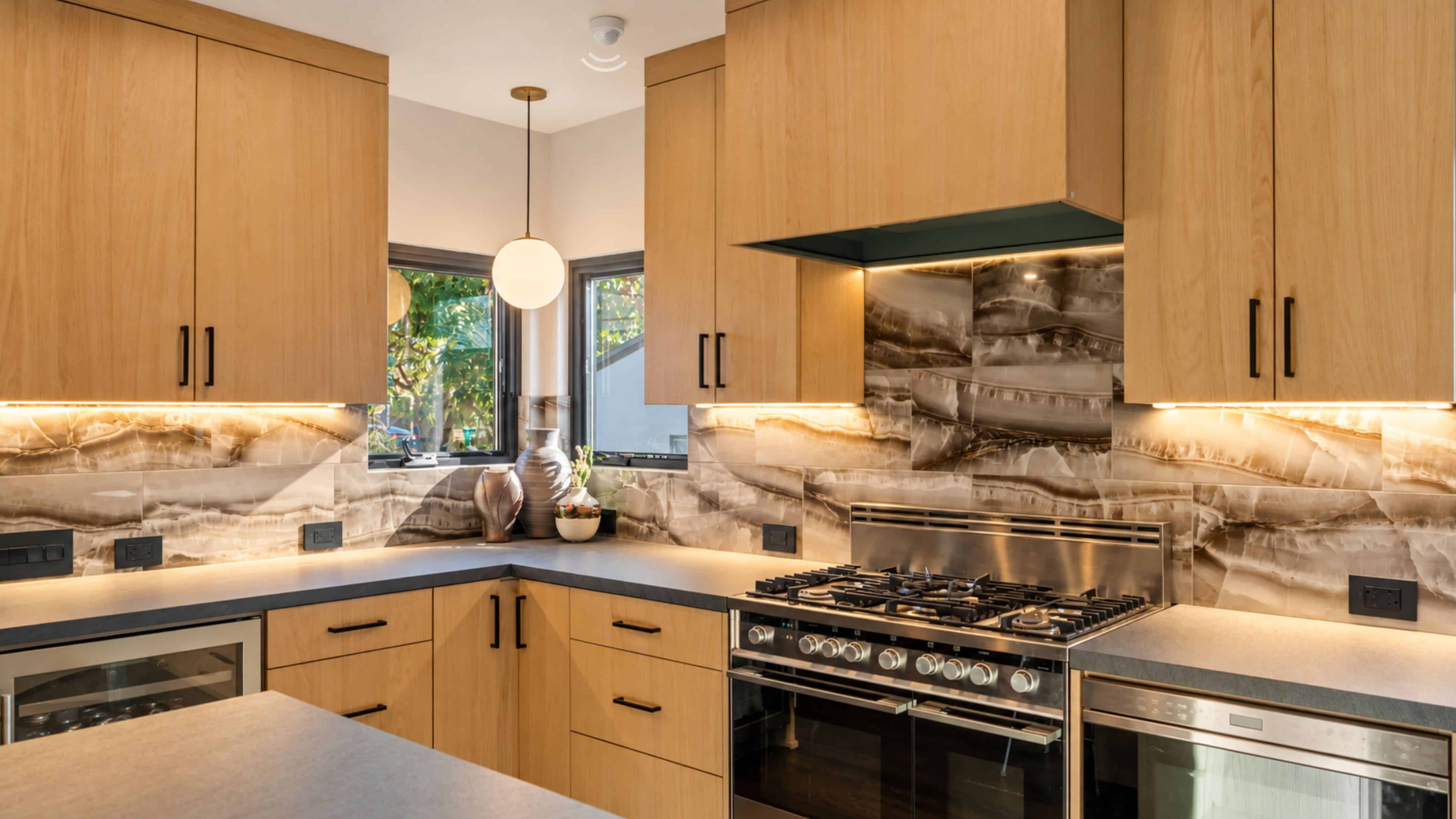 Aging-in-place kitchen with wood cabinetry, wide drawers, accessible hardware, and motion-sensor under-cabinet lighting illuminating the countertops.