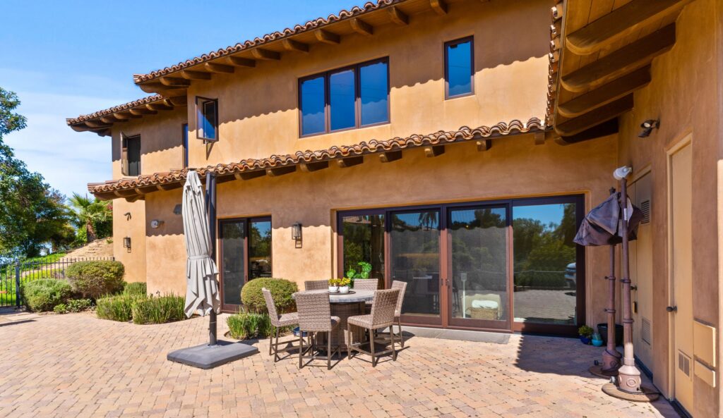 Exterior of the Poway garage-to-ADU conversion with stucco walls, tile roof, and patio doors