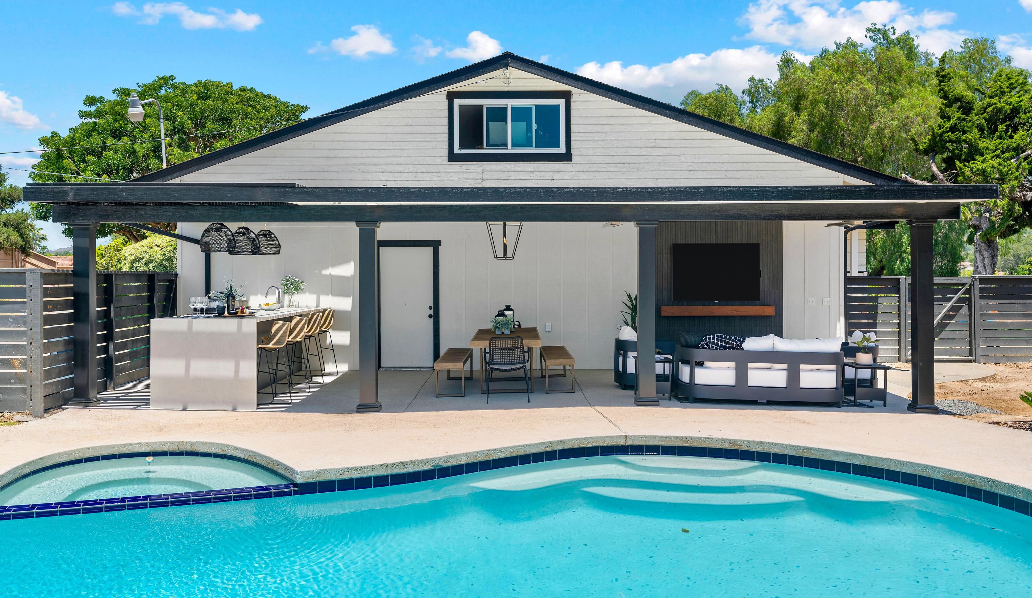 San Marcos outdoor living remodel with kitchen bar, dining, lounge seating, TV wall and pool under a covered patio