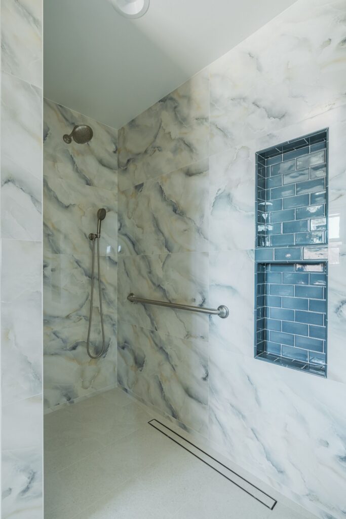 Bathroom double vanity with blue-gray shaker cabinets, quartz countertop, two framed mirrors and three-light vanity fixtures