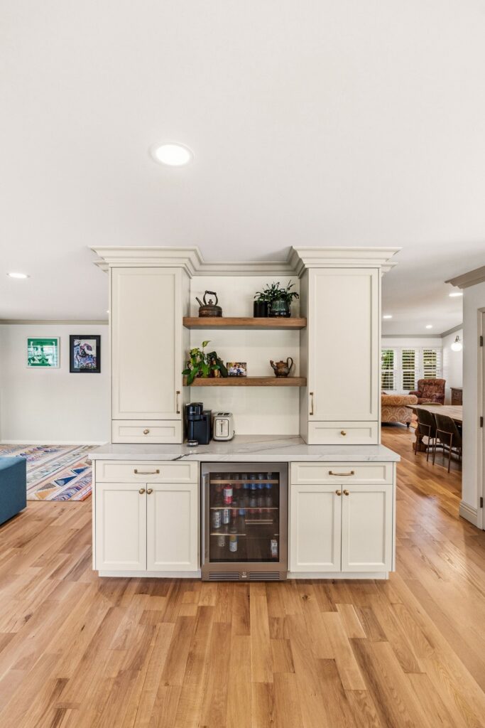 Pantry behind an arched reeded-glass wood door, with cookbook shelving, pull-out drawers and a schoolhouse pendant