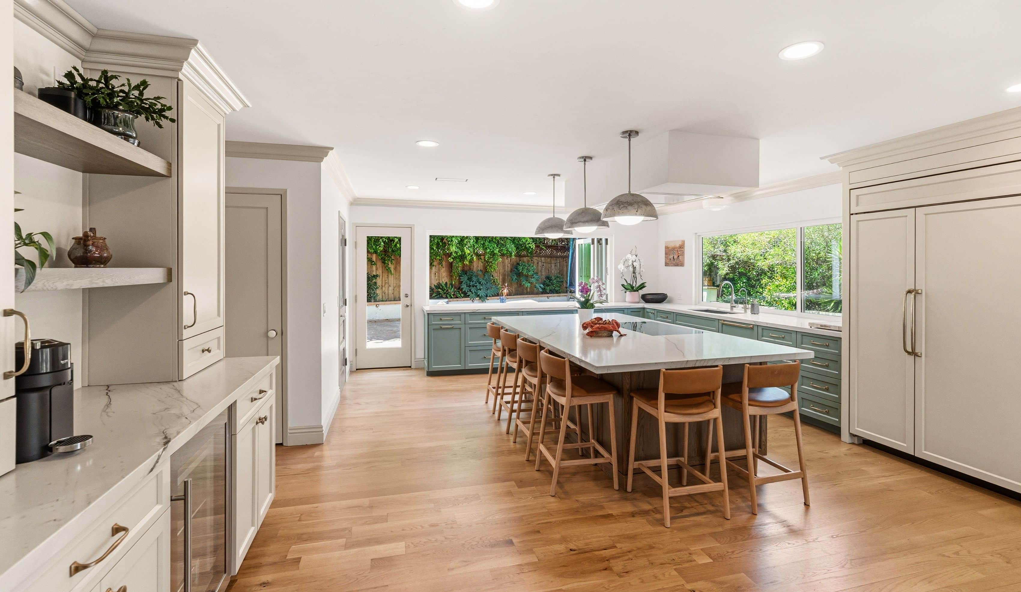 Allied Gardens kitchen addition with a six-stool island, concrete pendants, paneled refrigerator, beverage station and garden windows